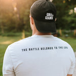 Back view of a man wearing the white smoke Grit & Giants Overcomer Training Tee featuring The Battle Belongs to the Lord.