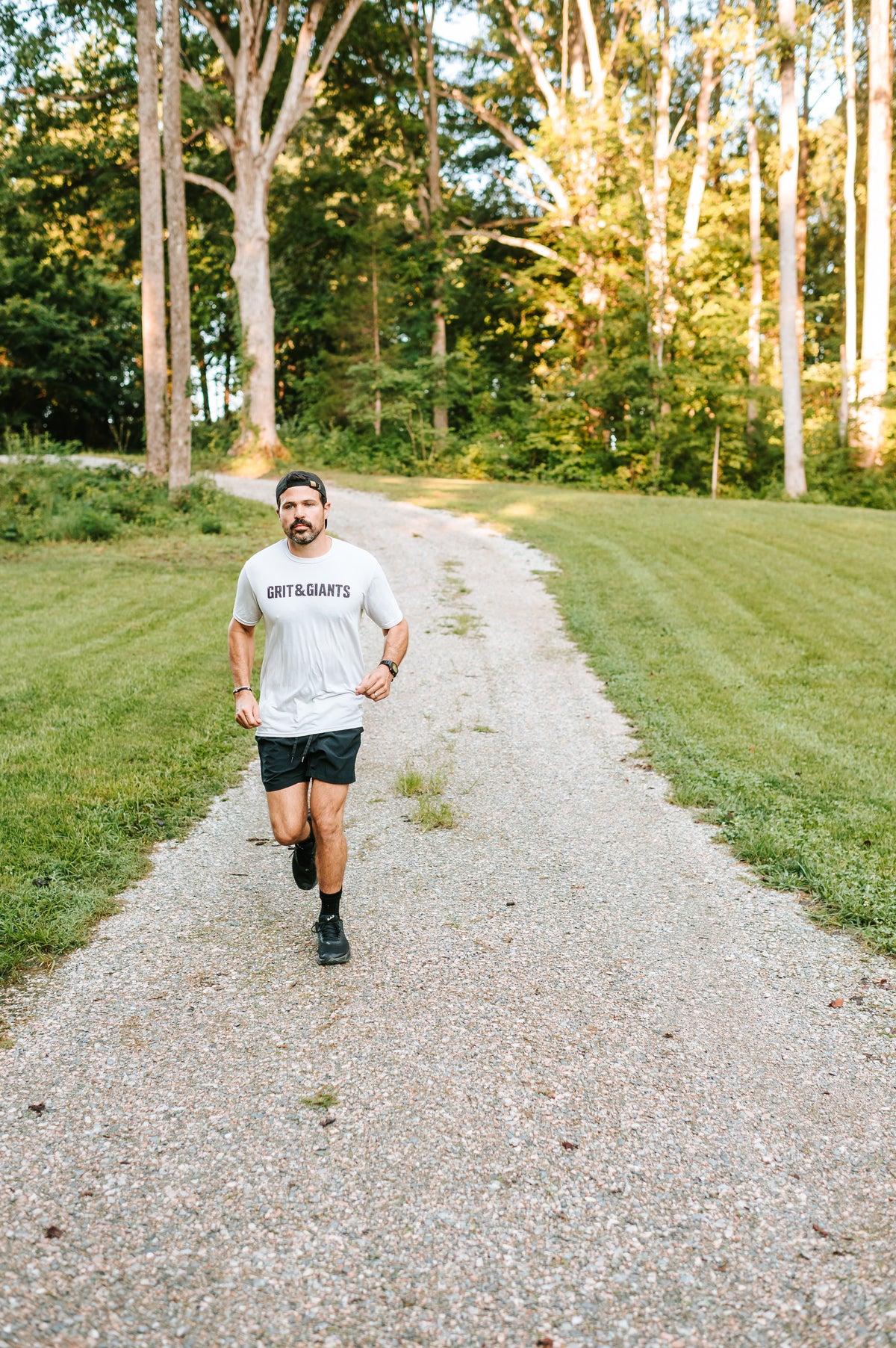 Man running outdoors in a Grit & Giants training tee.
